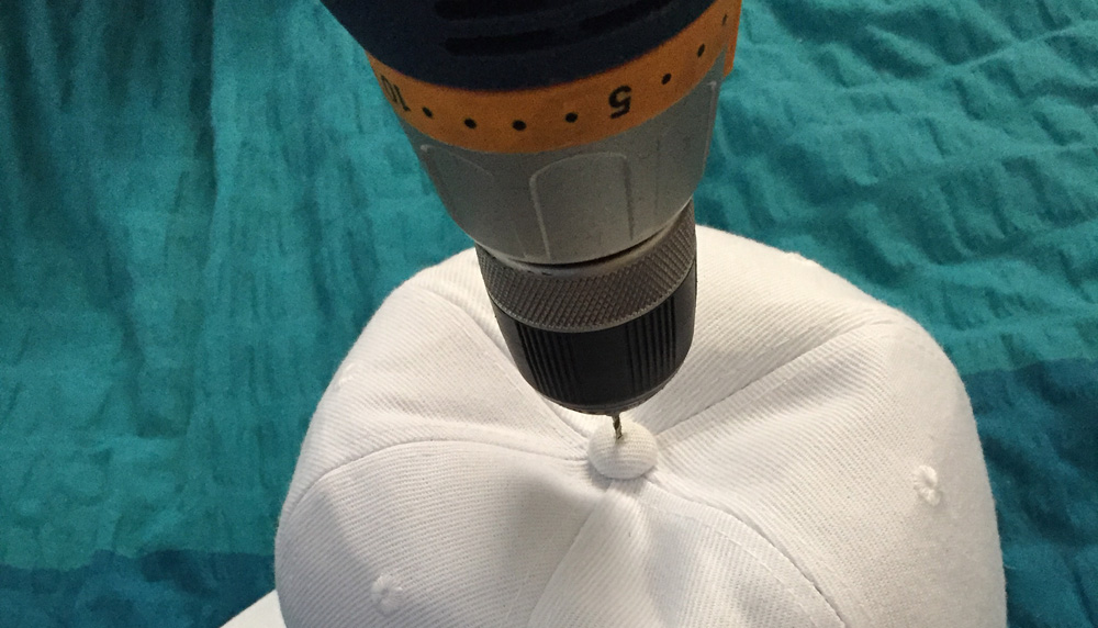 Drilling a hole through the top of the hat for the propeller mechanism.